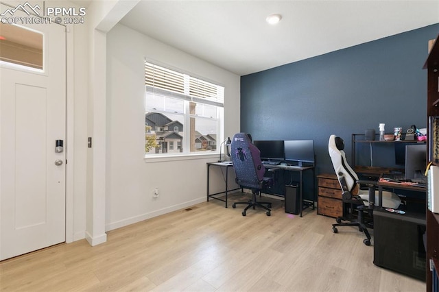 home office with light hardwood / wood-style flooring