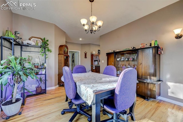 dining room with light hardwood / wood-style flooring and an inviting chandelier