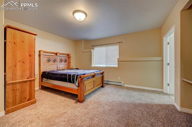 carpeted bedroom with a textured ceiling and a baseboard heating unit