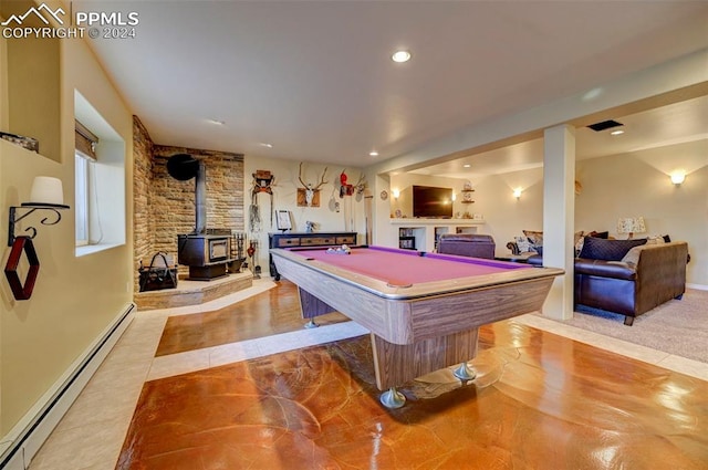 rec room with light tile patterned floors, a wood stove, baseboard heating, and pool table