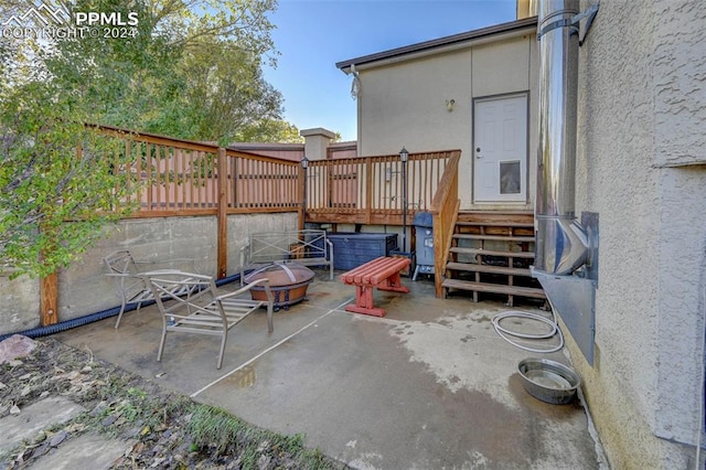 view of patio featuring a wooden deck and a fire pit