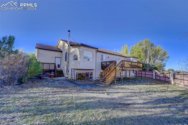 back of house with a lawn and a deck