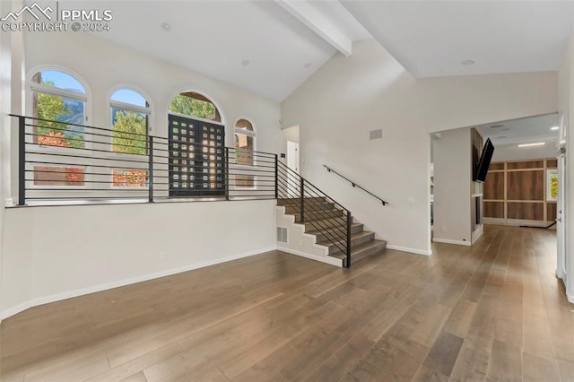 interior space featuring beam ceiling, high vaulted ceiling, and wood-type flooring