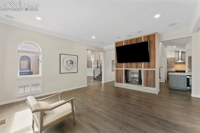 living area featuring crown molding and dark hardwood / wood-style flooring