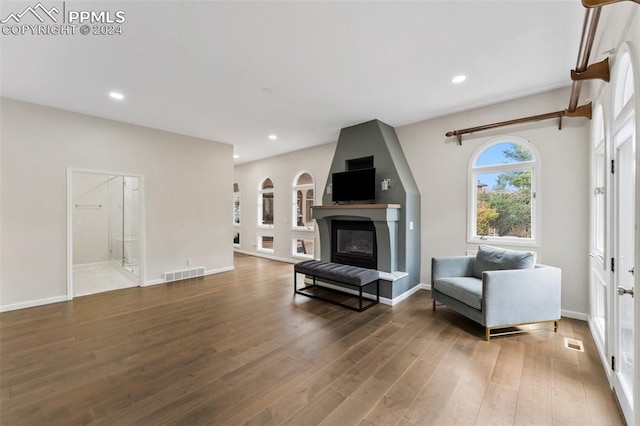 sitting room featuring hardwood / wood-style flooring and a large fireplace