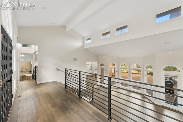 hallway featuring beamed ceiling, dark wood-type flooring, and high vaulted ceiling