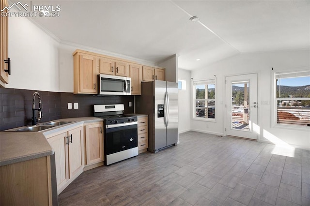 kitchen featuring decorative backsplash, stainless steel appliances, vaulted ceiling, sink, and light brown cabinets