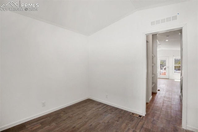 spare room featuring dark hardwood / wood-style floors and vaulted ceiling