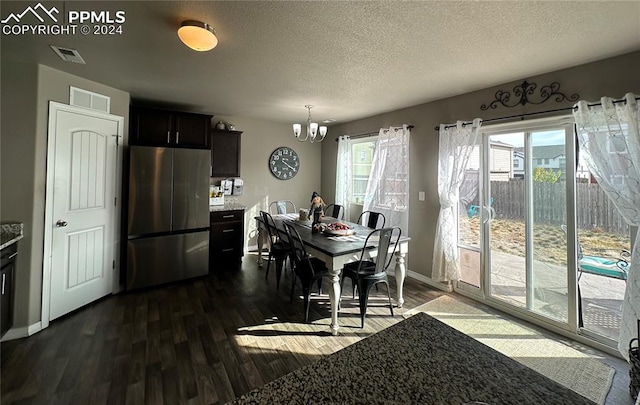 dining room featuring a notable chandelier, a textured ceiling, and dark hardwood / wood-style flooring