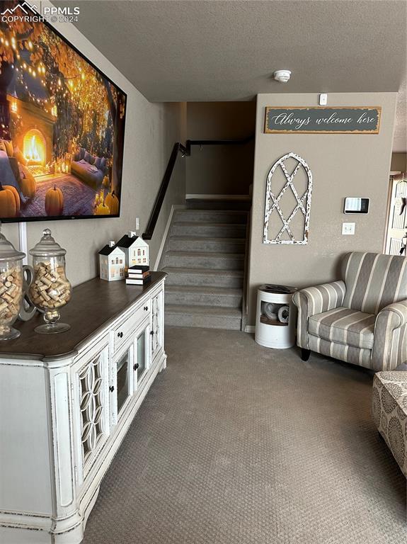 living room with a textured ceiling and dark carpet