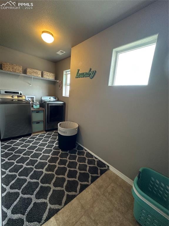 washroom with a textured ceiling and washing machine and dryer