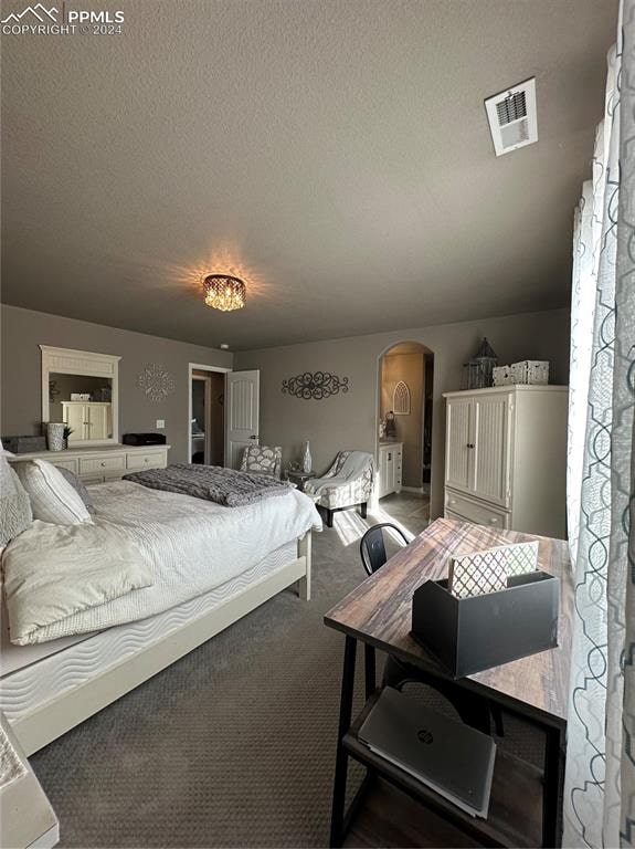 carpeted bedroom featuring a textured ceiling