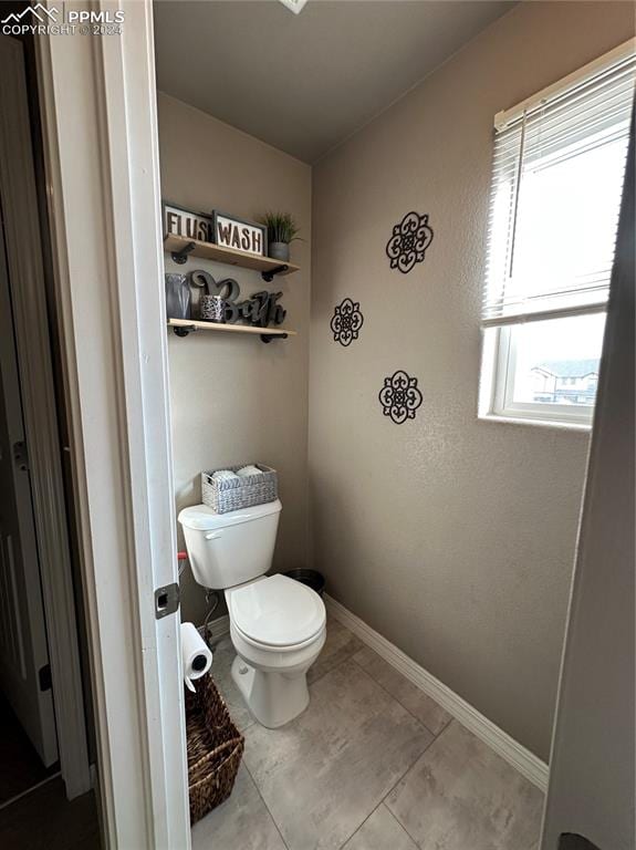 bathroom with toilet and tile patterned floors