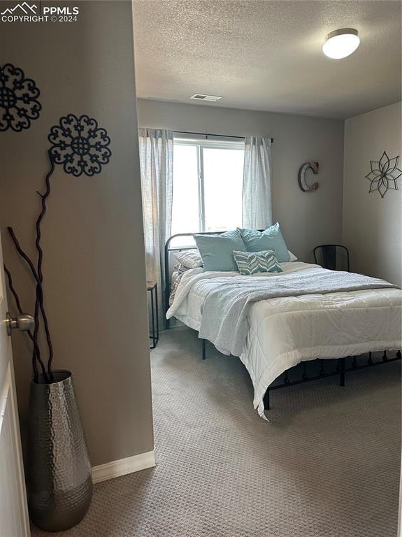 carpeted bedroom with a textured ceiling