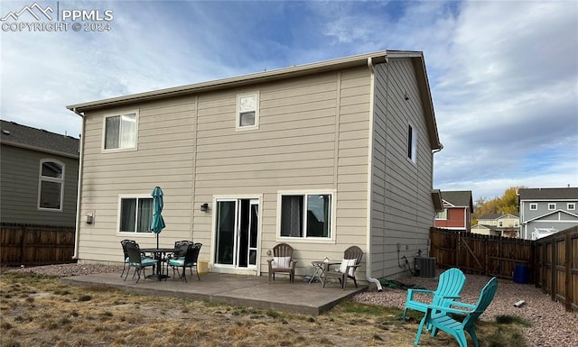 rear view of house with central air condition unit and a patio