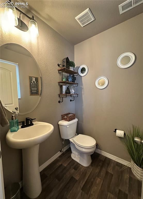 bathroom featuring wood-type flooring and toilet