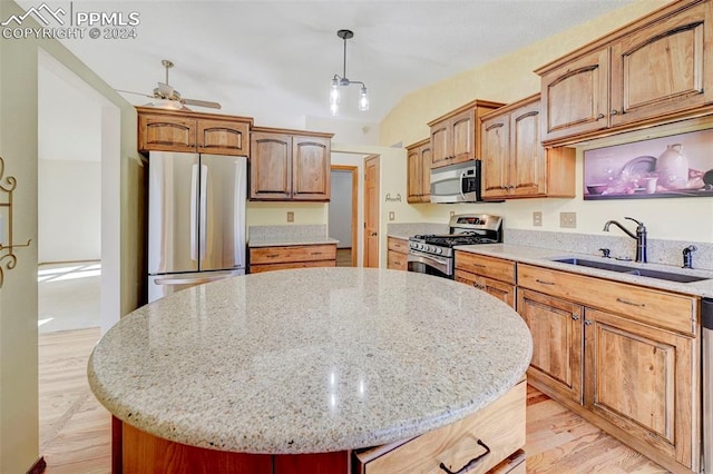 kitchen featuring a kitchen island, light hardwood / wood-style flooring, sink, decorative light fixtures, and appliances with stainless steel finishes