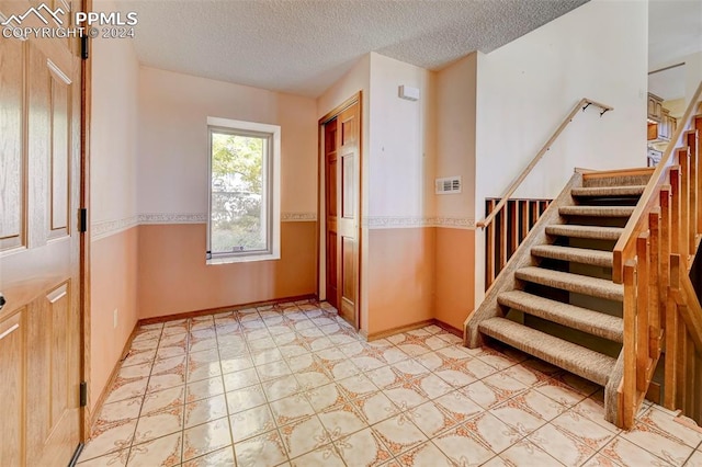 foyer with a textured ceiling