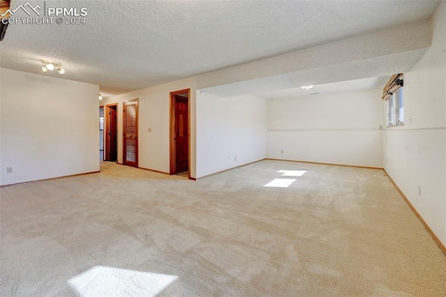 carpeted spare room featuring a textured ceiling