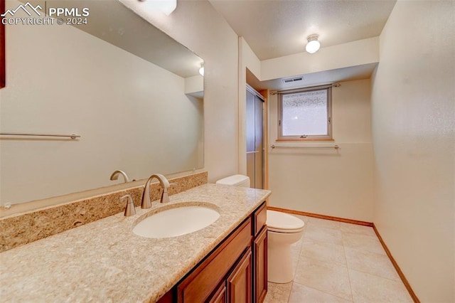 bathroom with vanity, toilet, and tile patterned flooring