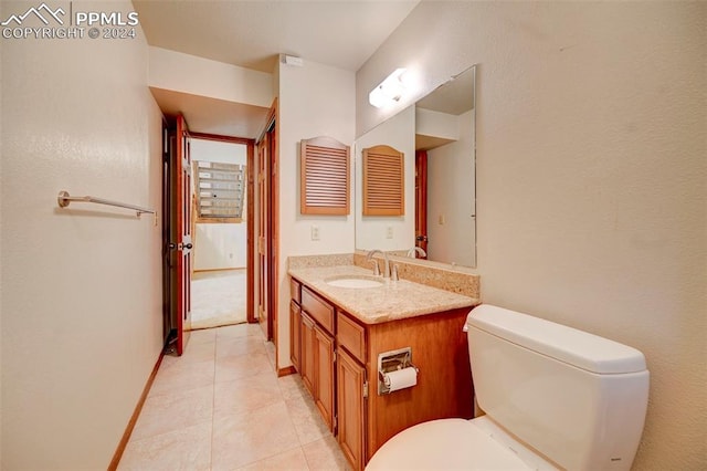 bathroom featuring toilet, vanity, and tile patterned flooring