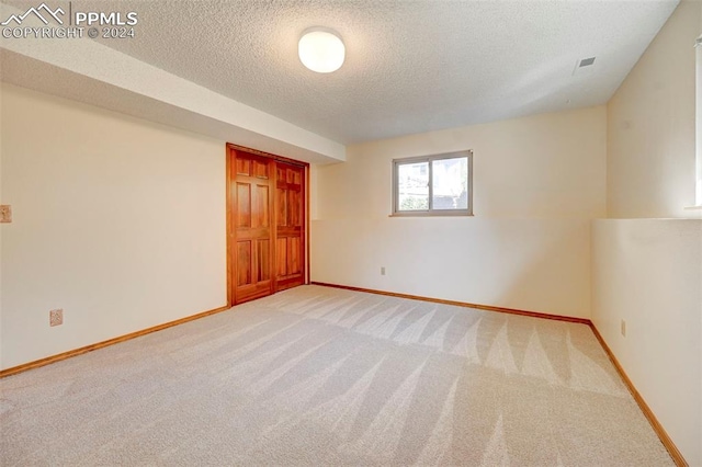 carpeted spare room featuring a textured ceiling