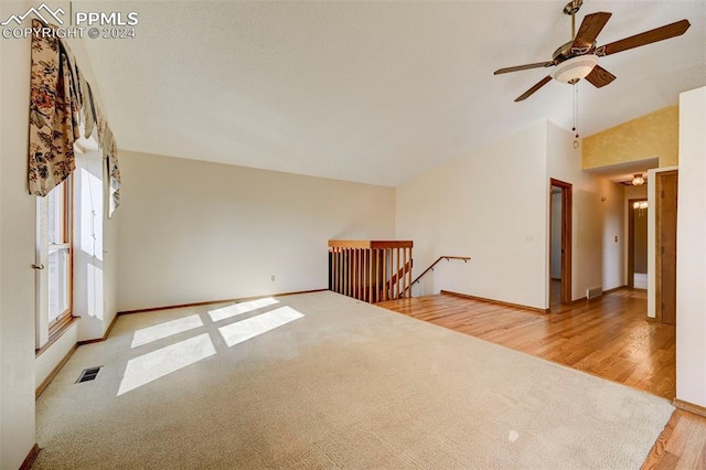 unfurnished room with lofted ceiling, wood-type flooring, and ceiling fan