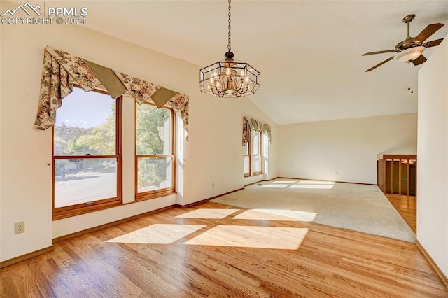 interior space featuring lofted ceiling, light wood-type flooring, and ceiling fan with notable chandelier