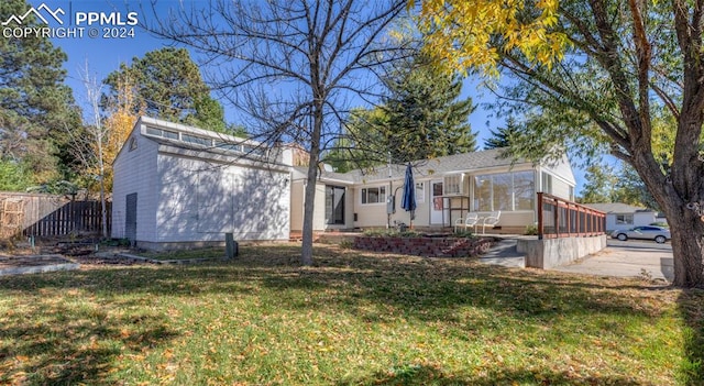 view of front facade with a front yard and a sunroom