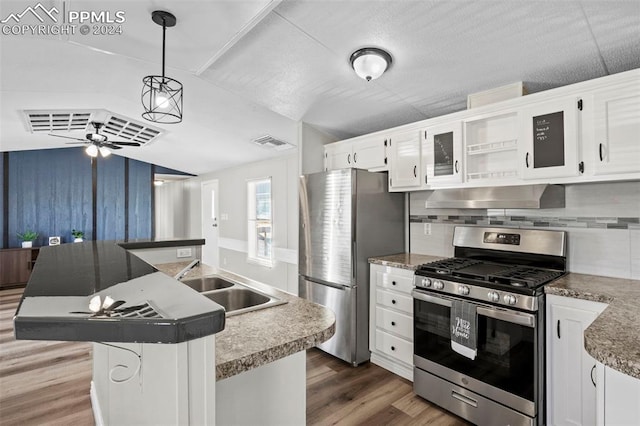 kitchen featuring appliances with stainless steel finishes, sink, hanging light fixtures, white cabinets, and dark wood-type flooring