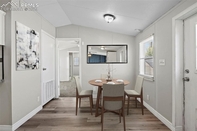 dining room featuring hardwood / wood-style flooring, ceiling fan, and vaulted ceiling