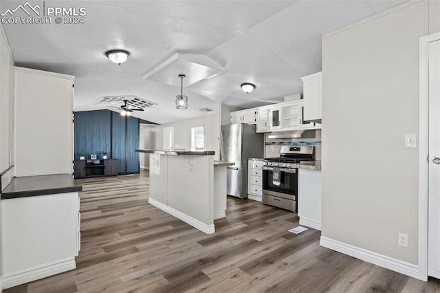 kitchen featuring lofted ceiling, white cabinets, stainless steel appliances, and pendant lighting