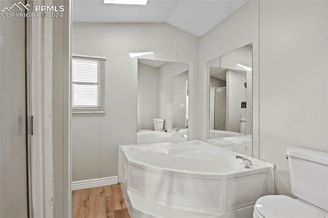 bathroom featuring toilet, lofted ceiling with skylight, independent shower and bath, and hardwood / wood-style floors