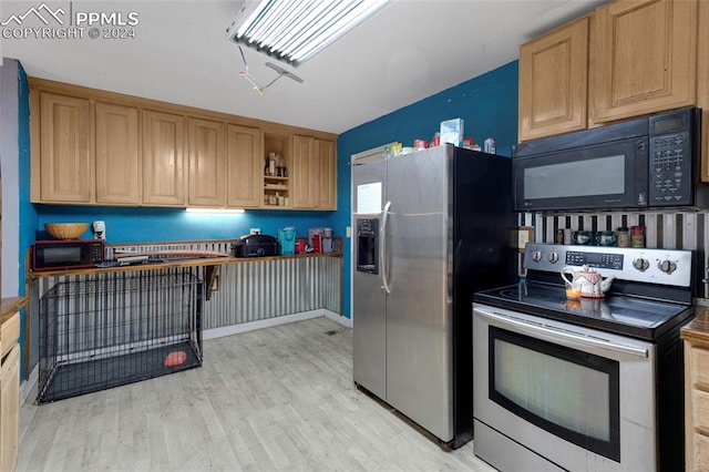 kitchen featuring appliances with stainless steel finishes and light hardwood / wood-style flooring