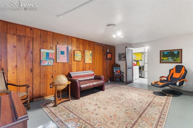 living room with wood walls and concrete flooring