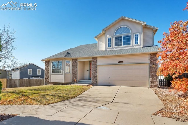 view of front property with a front lawn, central AC unit, and a garage