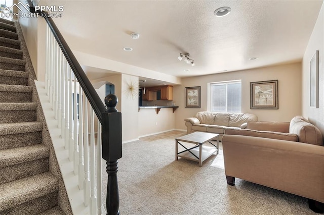 carpeted living room featuring a textured ceiling