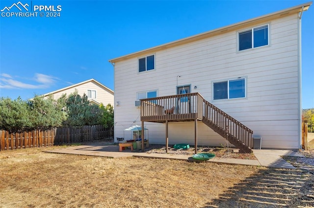 rear view of house featuring a wooden deck and a patio