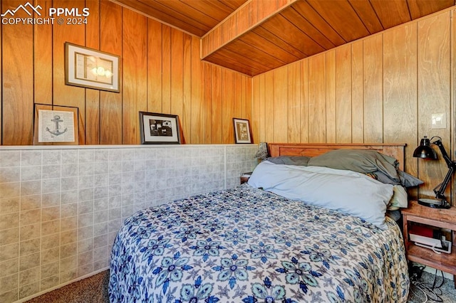 bedroom featuring wooden walls, wooden ceiling, and carpet