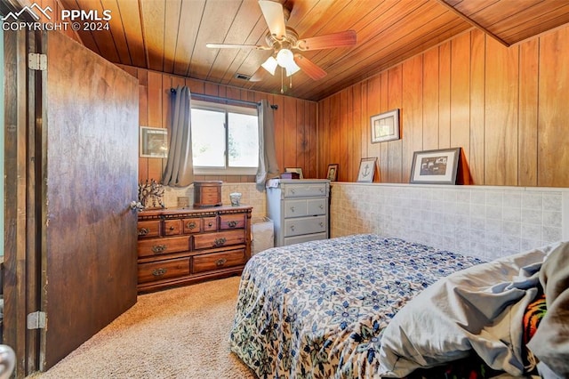 carpeted bedroom featuring wood ceiling, wood walls, and ceiling fan