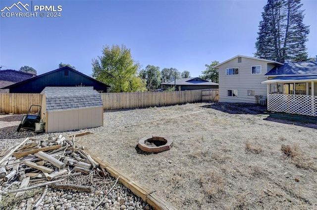 view of yard with a shed and a fire pit