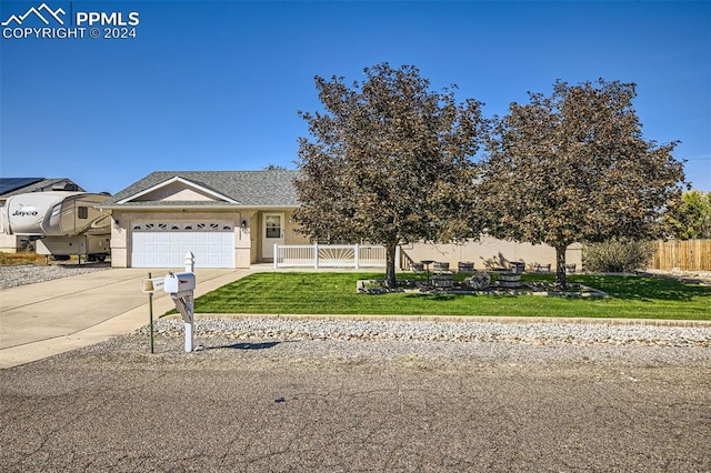 view of front of home with a front yard and a garage