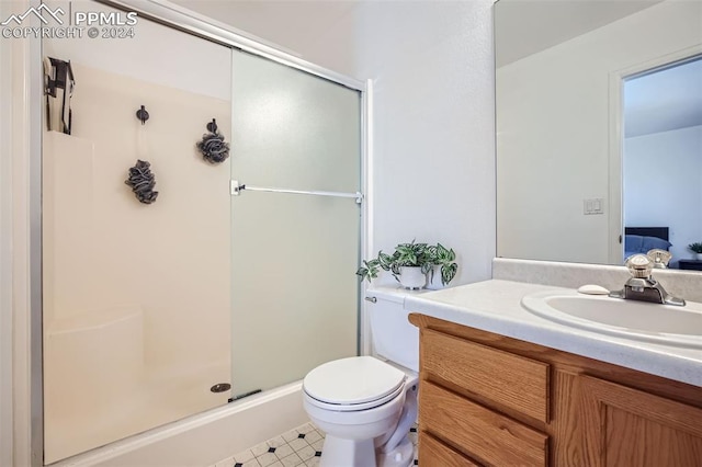 bathroom featuring vanity, an enclosed shower, toilet, and tile patterned flooring