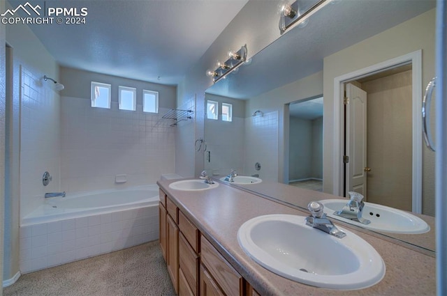 bathroom featuring vanity and tiled shower / bath