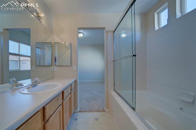 bathroom featuring vanity, enclosed tub / shower combo, and tile patterned flooring