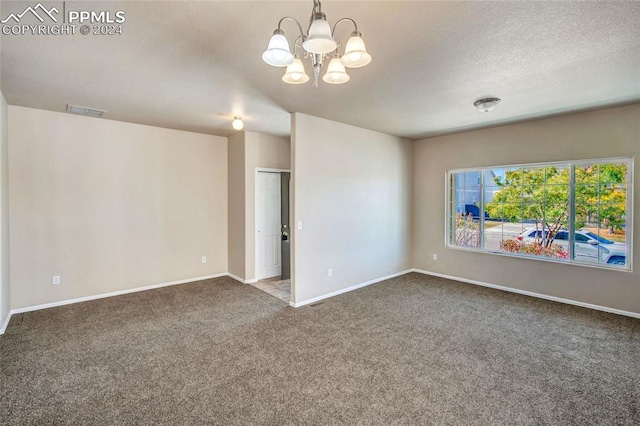 empty room with carpet flooring, a notable chandelier, and a textured ceiling