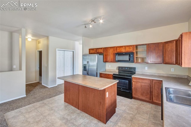 kitchen with black appliances, sink, light carpet, and a center island