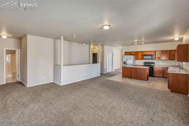 kitchen featuring black appliances, sink, light colored carpet, and a center island