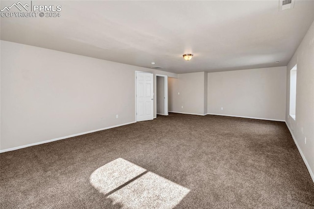 unfurnished room with dark carpet