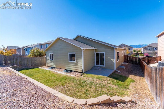 back of house with a lawn and a patio area